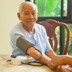 doctor measuring blood pressure of male patient